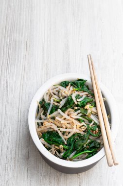 Kore ıspanak fasulyesi, beyaz ahşap masada salata. 