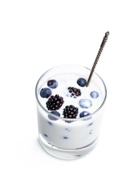 Beyaz bir bardakta taze meyveli yoğurt içmek. 