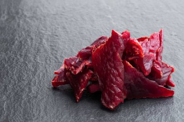 Siyah taş arka planda kurutulmuş et parçaları 