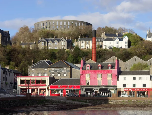 OBAN, SCOTLAND, MAY-07.2015, Oban-destilleriet og McCaig-tårnet – stockfoto