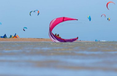 Uçurtma rekabet üzerinde ve insanların kitespot, gökyüzü, kiteboarding su sporları, aktif yaşam tarzı birçok uçurtma plaja izliyor