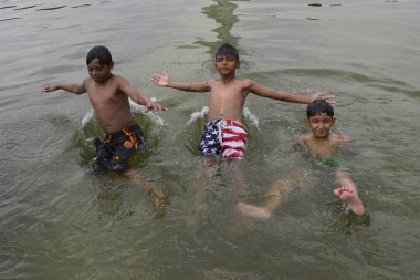  Sıcak bir günde dakka, Bangladeş'te Sohrawardi Uddan göle yüzmeye çocukların bir grup. 