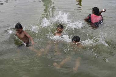  Sıcak bir günde dakka, Bangladeş'te Sohrawardi Uddan göle yüzmeye çocukların bir grup. 