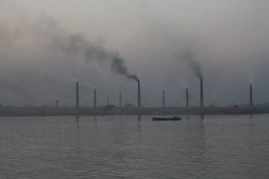 Buriganga Nehri kıyısındaki tuğla fabrikaları. Bu fabrikaların bacalarından çıkan kara duman çevreye ve ekosisteme ciddi bir tehdit oluşturuyor. Dhaka, Bangladeş