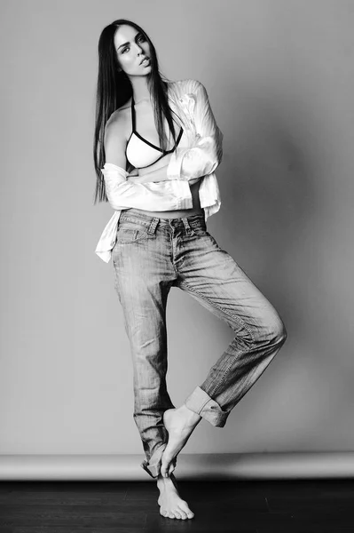 Привлекательная девушка в джинсах, рубашке и лифчике — стоковое фото