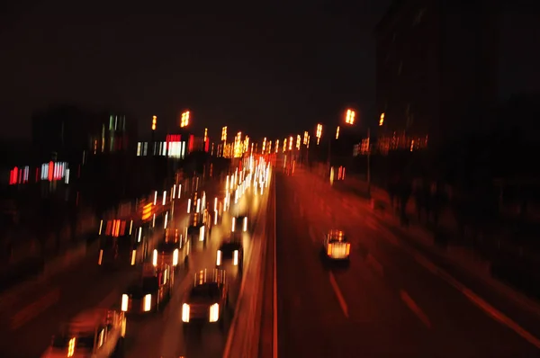 Blurred view of busy highway with vehicles at night