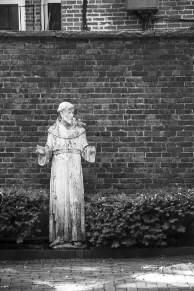 Svart och vit staty Saint Francis Brick Wall — Stockfoto