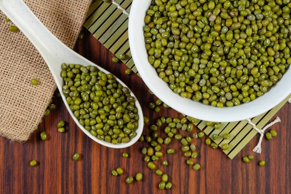 Mung beans on wooden table and metalspoon