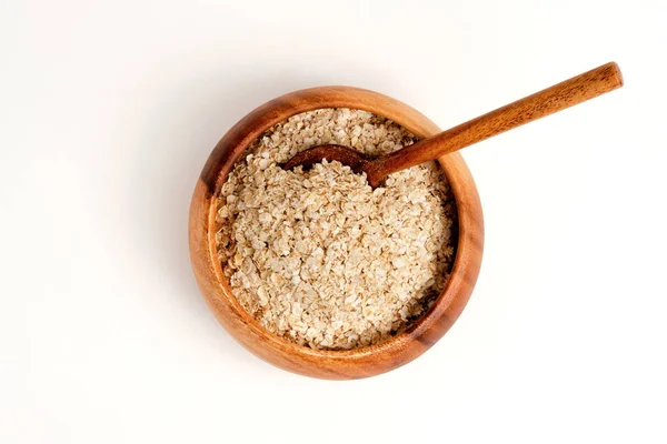 Farina d'avena in ciotola di legno e fondo bianco — Foto Stock