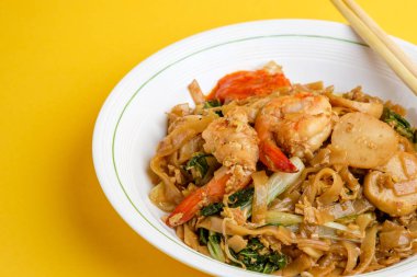 Kızarmış düz pirinç noodle veya char kway teow karıştırın