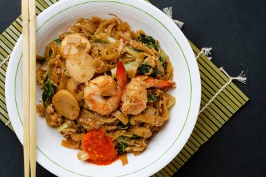 Kızarmış düz pirinç noodle veya char kway teow karıştırın