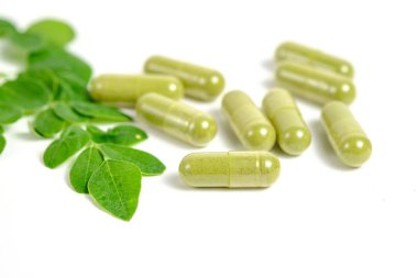 Beyaz arkaplanda Moringa yaprakları ve kapsülleri