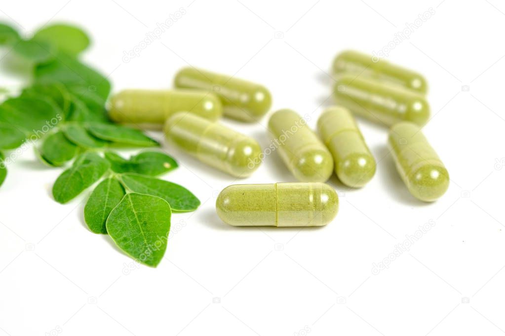 Moringa leaves and capsules on white background
