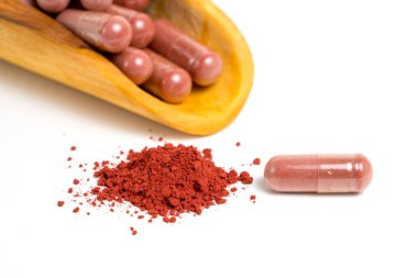 Kırmızı maya pirinci veya angkak veya kojic pirinç tozu ve beyaz izole edilmiş arka plan takviye kapsülü
