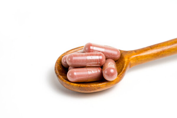 Red yeast rice supplement capsules on white background