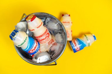 Makati city of Manila, Philippines. Mar 09 2020: Yakult and Yakult Light fermented milk drink on yellow isolated background. Healthy probiotic drink with the bacteria strain Lactobacillus paracasei Shirota.