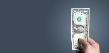 Elinde küçük bir banknot tutan genç adam