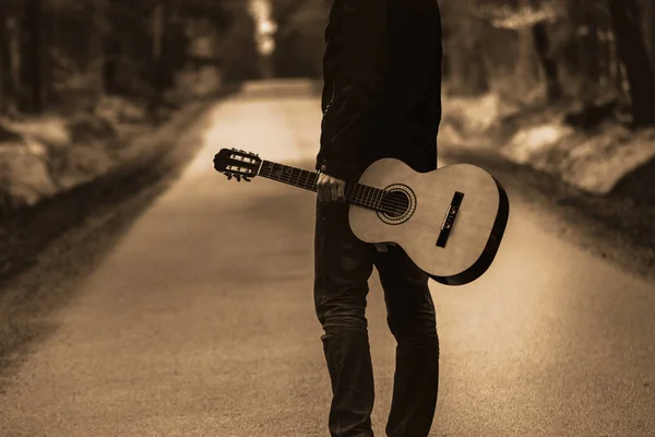 Személy azon az úton, a gitár. Ingyenes utazás az ország eszköz erdő. — Stock Fotó