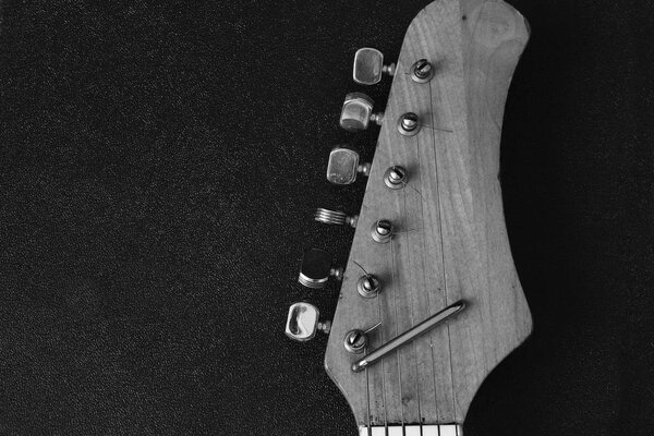 Wodenn neck of eletric guitar on the black backround.