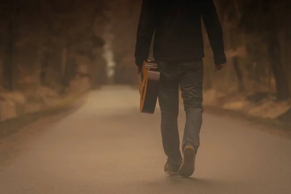 Gitar ile yürüyüş kişi