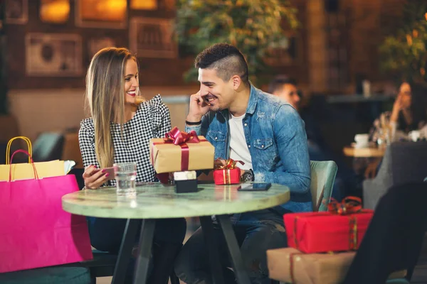 Νεαρό ζευγάρι απολαμβάνει το κατάστημα καφέ μετά από χριστουγεννιάτικα ψώνια — Φωτογραφία Αρχείου