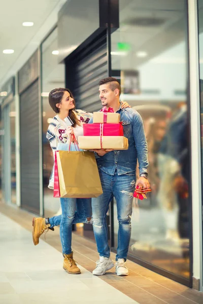 Couple avec cadeaux de Noël, cadeaux et sacs à provisions dans un centre commercial — Photo