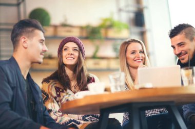 Bir grup genç insan eğleniyor bir kafede oturan