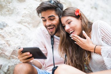 Merdivenlerde oturan ve tablet bilgisayar başında arıyor Romantik Çift