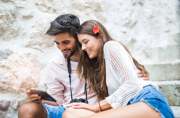 Merdivenlerde oturan ve tablet bilgisayar başında arıyor Romantik Çift