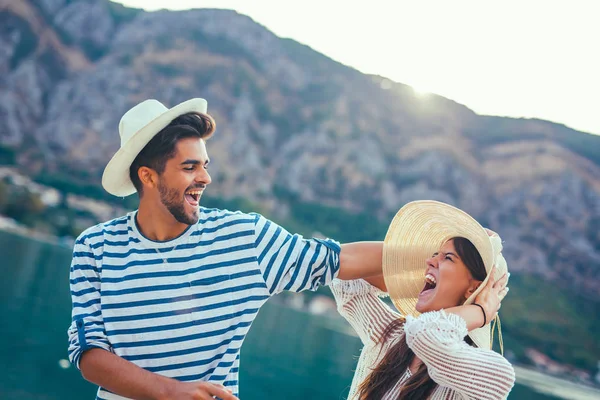 Felice giovane coppia a piedi dal porto di una località balneare turistica — Foto Stock