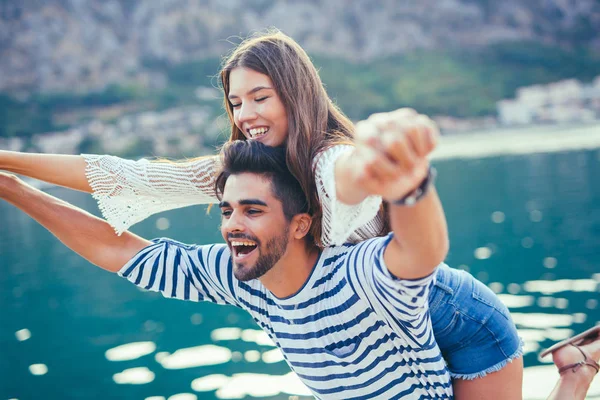 Glückliches junges Paar beim Spaziergang am Hafen eines touristischen Badeortes — Stockfoto