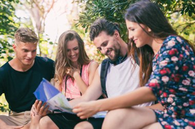 Turistler için yön kağıt harita kullanarak arama gençler