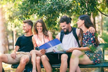 Turistler için yön kağıt harita kullanarak arama gençler