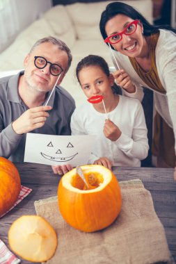Aile Cadılar Bayramı kutluyor. Onlar masada oturuyorlar 