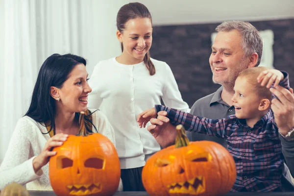 Rodinný řezbářských Velká oranžová dýně na Halloween a baví — Stock fotografie