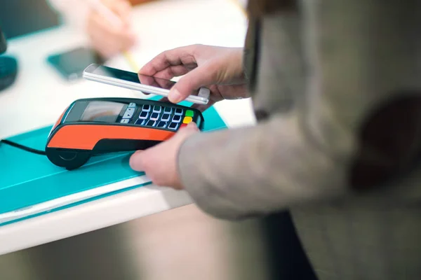 Man met mobiele telefoon te betalen in de winkel — Stockfoto