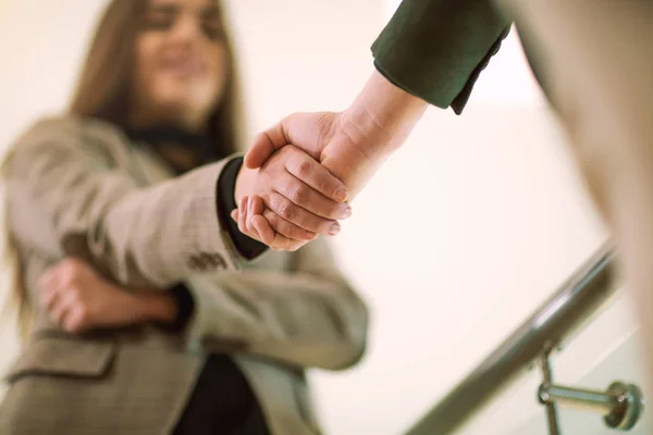 Välkomnande affärskvinna ger ett handslag och leende — Stockfoto