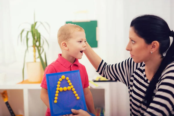 Niño pequeño durante la lección con su terapeuta del habla — Foto de Stock