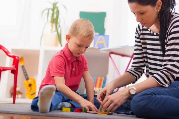 Barn pojke och mamma leker med pedagogiska leksak — Stockfoto