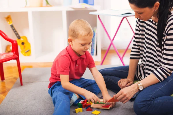 Barn pojke och mamma leker med pedagogiska leksak — Stockfoto