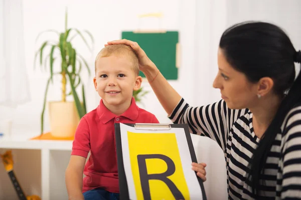 Logoped učí chlapce říci písmeno R — Stock fotografie