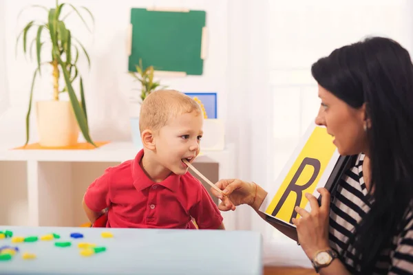 言語聴覚士に文字 R を言う男の子を教えています。 — ストック写真
