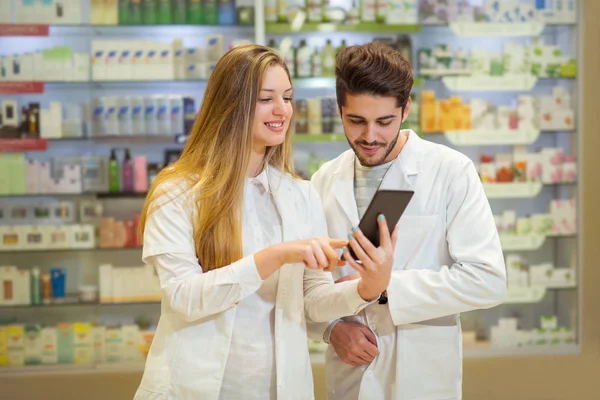 Apotheker nutzen digitales Tablet bei Medikamentenkontrolle in Apotheke — Stockfoto