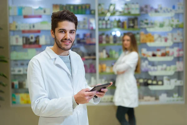 Portret Farmaceuta posiadający cyfrowe tabletki w aptece, w th — Zdjęcie stockowe