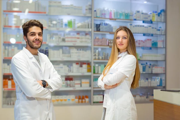 Farmacêuticos femininos e masculinos em farmácia — Fotografia de Stock
