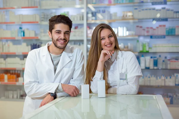 Farmacêuticos femininos e masculinos em farmácia — Fotografia de Stock
