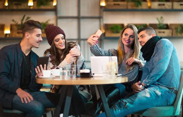 Groupe de jeunes assis dans un café s'amusant — Photo