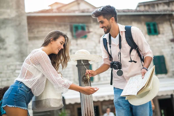 Pareja joven de turista cerca de una fuente de agua potable — Foto de Stock