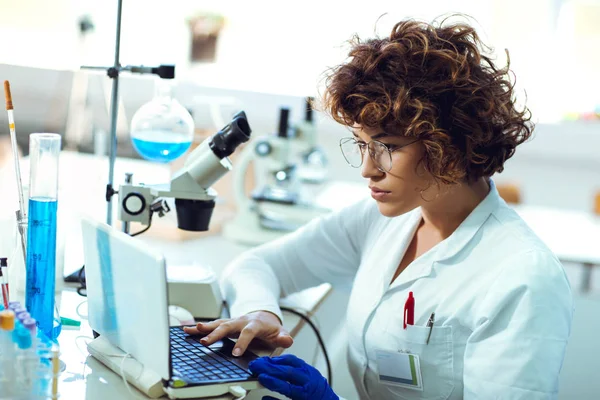 Retrato de mujer científica confiada trabajando en el ordenador portátil en química — Foto de Stock