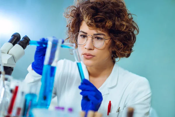 Young attractive female scientist in protective eyeglasses and g — Stock Photo, Image